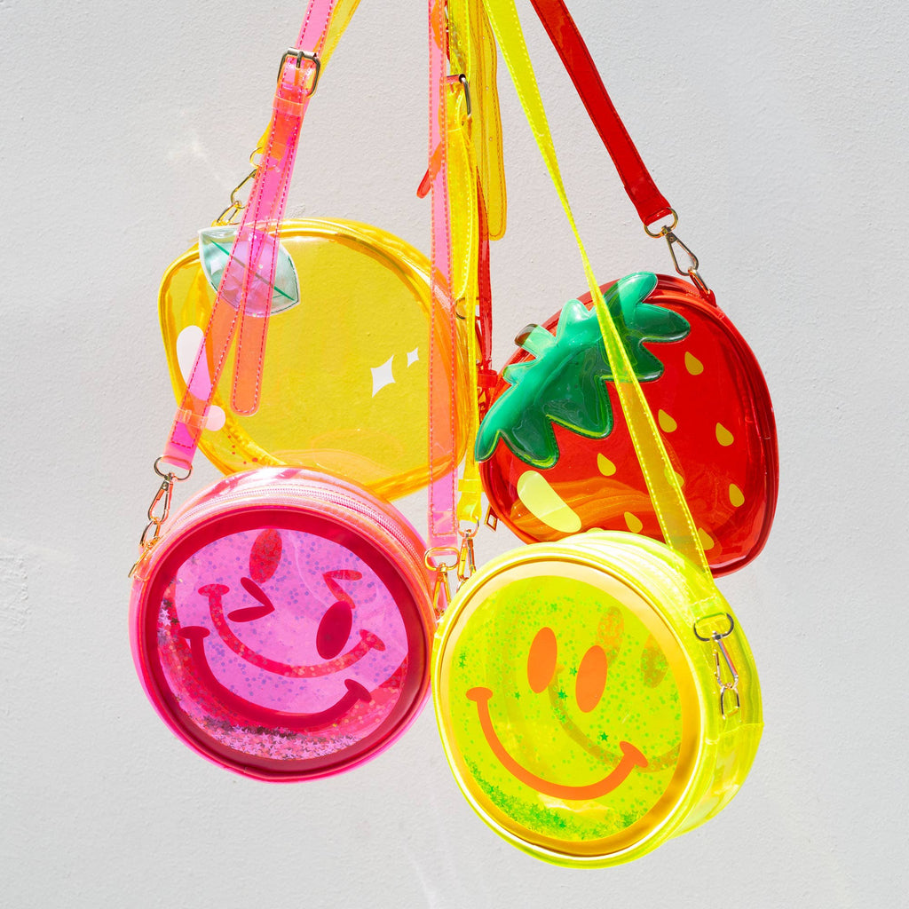 Colorful transparent bags with strawberry and smiley face designs on a white background